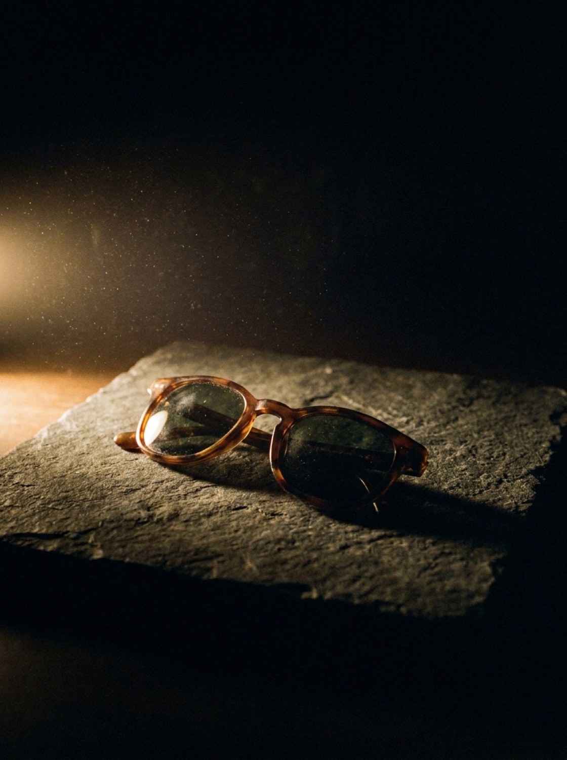 Lichtserie: Sonnenbrille auf Schieferplatte im harten Seitenlicht